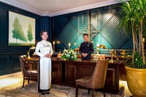a woman standing in front of a bar with a man at Silverland Jolie Hotel in Ho Chi Minh City +65 photos