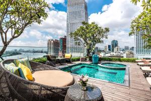 un patio en la azotea con piscina y vistas a la ciudad en Silverland Jolie Hotel en Ho Chi Minh