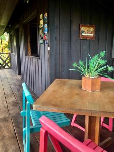 une table en bois avec des chaises et une plante en pot sur une terrasse couverte dans l'établissement Casa Campestre estilo Chalet Los Pirineos - Cerca a Cali, à Cali