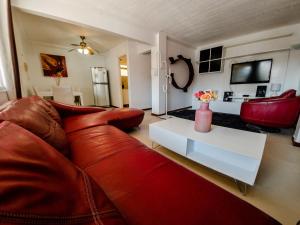 sala de estar con sofá rojo y mesa blanca en Departamento Borgoño, en Viña del Mar