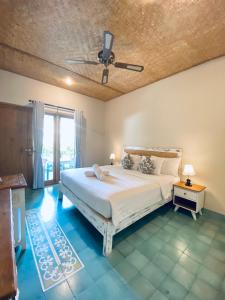 a bedroom with a bed and a ceiling fan at Jukung Dua Guest House in Sanur
