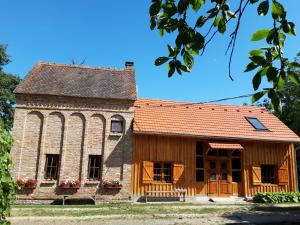 une ancienne église en pierre avec un toit rouge dans l'établissement Cserépmadár szállás és Csinyálóház, à Velemér