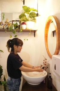 a woman washing a toilet in a bathroom at SEMERU HOSTEL MALANG in Malang +33 photos