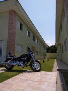 una motocicleta estacionada frente a un edificio en Bertioga Praia do SESC - Apartamento de 2 quartos, en Bertioga