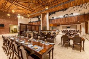 a large dining room with a long table and chairs at The Baagh Ananta Elite Ranthambore in Sawāi Mādhopur