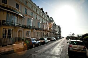 a row of cars parked on a street with buildings at Brighton House in Brighton & Hove