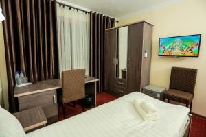 苦盏Sugdiyon Hotel的一间带床、桌椅的酒店房间 更多23张照片