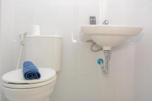 ein weißes Badezimmer mit Toilette und Waschbecken in der Unterkunft Comfy Studio Room at Patraland Urbano Apartment By Travelio in Bekasi + 6 Fotos