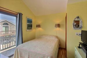 a bedroom with a bed and a window with a balcony at NC 12 56821-40 Condo in Hatteras