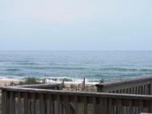 a view of the ocean from a wooden deck at NC 12 56821-40 Condo in Hatteras +2 photos
