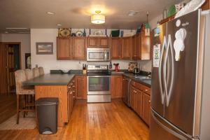 Una cocina con gabinetes de madera y un refrigerador de acero inoxidable. en 56188 Austin Road Home, en Hatteras 9 fotos más