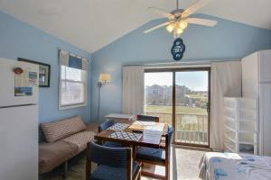 a living room with a dining room table and a refrigerator at NC 12 56821-29 Condo in Hatteras