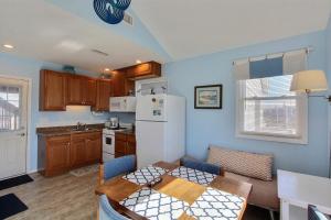 a kitchen with a table and a white refrigerator at NC 12 56821-29 Condo in Hatteras