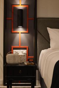 a bedroom with a bed and a clock on a night stand at Villa De Pranakorn in Bangkok