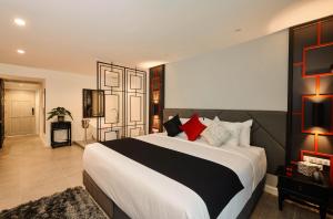 a bedroom with a large bed with red pillows at Villa De Pranakorn in Bangkok