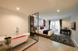 a bedroom with a bed and a bath tub and a bed sidx sidx sidx sidx at Villa De Pranakorn in Bangkok