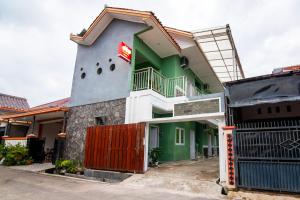 a building with a red door and a flag at Super OYO 2808 D'residence Syariah in Tegal