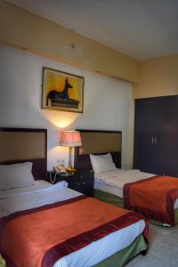 una camera d'albergo con due letti e una lampada di Desert View Sharm Hotel a Sharm El Sheikh