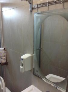 a bathroom with a mirror and a sink and a toilet at Hotel Cristina in Bocas del Toro