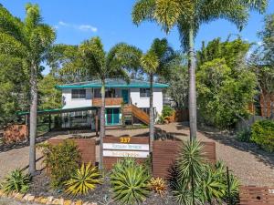 a house with palm trees in front of it at Torquay Terrace Bed & Breakfast in Hervey Bay