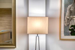 a lamp in the corner of a room with a mirror at Delightful Stylish Two Bedroom Condo in Hip Area of Central Athens in Athens