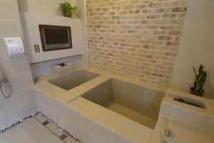 a bathroom with a tub, sink, and toilet at King's Garden Villa in Baihe