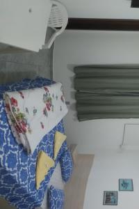 a bed with a pillow and a drying rack at Pousada Mama Jo in Casimiro de Abreu