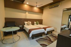 a bedroom with a bed and a table in a room at Dibrugarh Club House in Dibrugarh