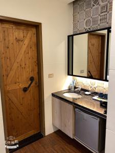 a bathroom with a wooden door and a sink at Hido Hostel II in Kenting