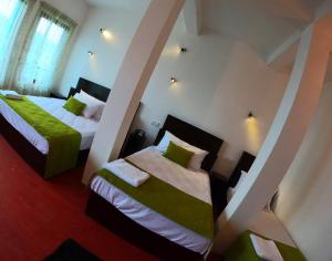 a bedroom with two beds with green and white sheets at Ella Ravana Seetha Mountain View Villa in Ella