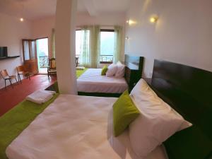 a hotel room with two beds and a balcony at Ella Ravana Seetha Mountain View Villa in Ella