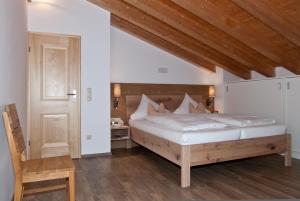 um quarto com uma cama grande e uma cabeceira em madeira em Ferienwohnungen Trinkl em Bad Wiessee