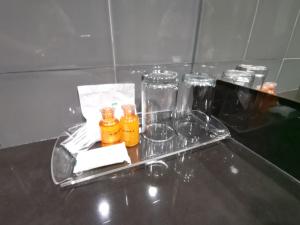 a tray with four glass bottles on a table at Twin Hotel in Phuket