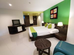 a hotel room with a bed and a tv at Twin Hotel in Phuket