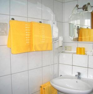 a bathroom with yellow towels and a sink at Gästehaus Kleine Kalmit in Landau in der Pfalz +22 photos
