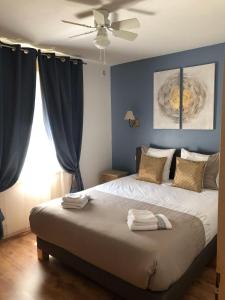 Cénac-et-Saint-JulienにあるChambres Les Plantous de Severoのベッドルーム1室(青い壁のベッド1台、天井ファン付)