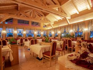 un restaurante con mesas y sillas en una habitación en Hotel Barance, en Alleghe