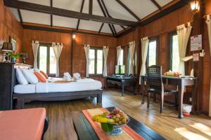 ein Schlafzimmer mit einem Bett und einem Schreibtisch mit einem Klavier in der Unterkunft ThaiLife Wellness & Meditation Resort- SHA Plus in Khao Lak