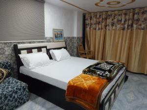 um quarto com uma cama grande e uma janela em Traveller Guest House em Varanasi