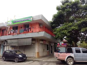 un edificio con un camión estacionado frente a él en Ranau Backpackers Hostel, en Ranau