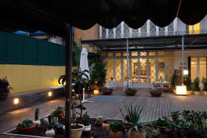 バルセロナにあるB&B Boutique Ca La Mariaの鉢植えの植物と傘が置かれた中庭