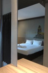 a reflection of a bedroom with a bed in a mirror at Paramount Palace Hotel Dannok in Sadao