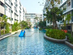 a pool in the middle of a city with buildings at The Trust Condo Huahin by Petcharat in Hua Hin