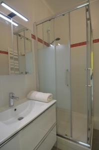 baño blanco con ducha y lavamanos en Appartement 4 personnes avec Vue Mer exceptionnelle à Villefranche-sur-Mer, en Villefranche-sur-Mer