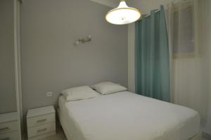 a small bedroom with a white bed and a light at Appartement 4 personnes avec Vue Mer exceptionnelle à Villefranche-sur-Mer in Villefranche-sur-Mer