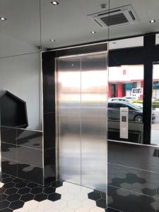 a metal elevator in a room with a tv at ARENA Boutique Hotel Kuala Terengganu in Kuala Terengganu