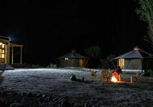 a person sitting around a camp fire at night at Chalet Seabuckthorn - Hunder in Hundar