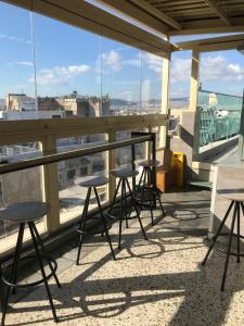 a row of tables and stools on a balcony at Safestay Athens Monastiraki in Athens