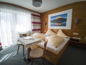 una camera d'albergo con un letto e un tavolo di Gästehaus Panorama a Biberwier