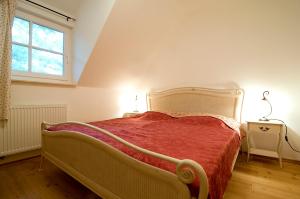 1 dormitorio con 1 cama con manta roja y ventana en Ferienhaus Zander mit Sauna, en Born